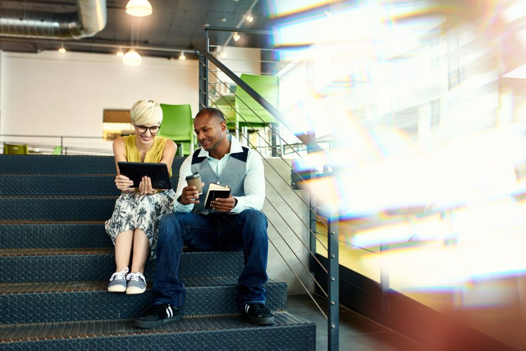 Two creative millenial small business owners working on social m